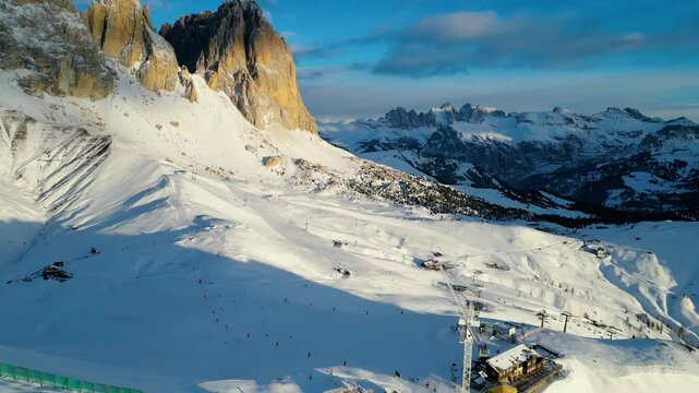 The Stazione di Arrivo Funivia Campitello and the Forcella del Sassolungo stand out in the breathtaking Val di Fassa ski resort in winter time captured by drone