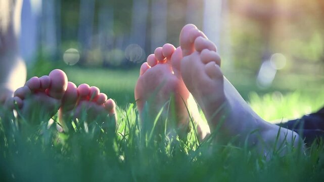 Child in backyard outside sitting on grass with bare feet showing for a childhood playing or podiatry concept.