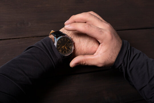 man pointing at hand watch