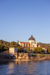View of the old town with church on river and hills italy 