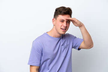 Obraz premium Young handsome Brazilian man isolated on white background looking far away with hand to look something
