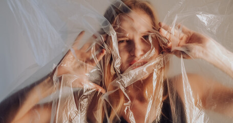 Lonely woman. Depressive mood. Disturbed concerned girl trapped behind wrinkled transparent...