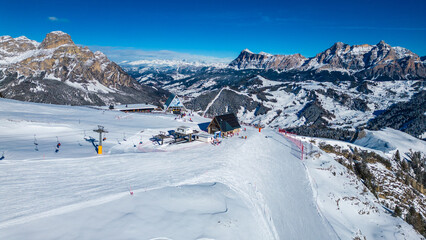 Gruppo del Sella and the famous Sellaronda ski circuit shine in this breathtaking winter aerial view, captured by drone. The Piz Boè station on the Alta Badia ski resort reveals its alpine charm