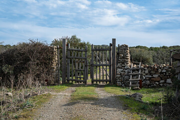 Rustic wooden gate with dry stone wall in a rural countryside