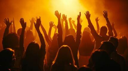Fototapeta premium A crowd of people are gathered together, with their hands raised in the air