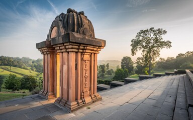 Obraz premium Sunrise illuminates ancient stone shrine atop hill overlooking valley.