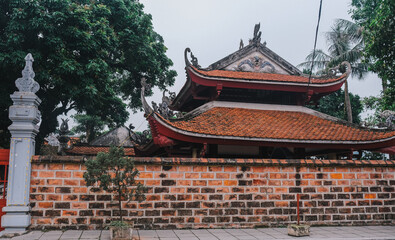 This captivating scene showcases a stunning historic temple embraced by vibrant greenery and resilient brick walls