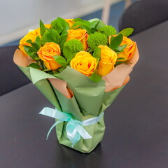 A bouquet of yellow roses in close-up on a table background