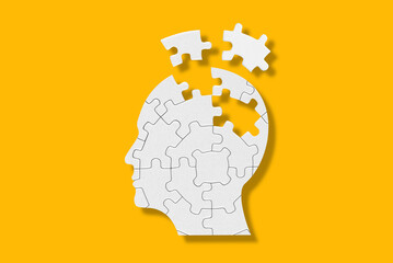 Head and brain diseases concept. A missing pieces of the brain puzzle on yellow background.