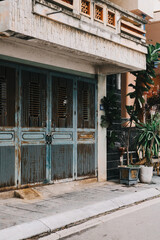 A rustic entrance with weathered doors is beautifully framed by lush greenery in a vibrant urban setting