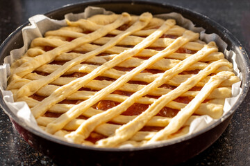 Making a Sweet Jam Pie, topped with a lattice-like woven pastry.