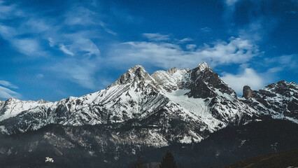 Snow-covered landscapes create a magical winter scene, with serene lakes, majestic mountains, and frosted hills under a crisp, clear sky.