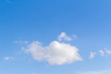 White airy beautiful clouds in a bright blue sky. Clear sunny weather. The concept of environmental safety and cleanliness..