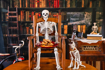 skeleton child sitting in vintage rocking chair with skeleton dog eating grilled cheese sandwiches with old library background
