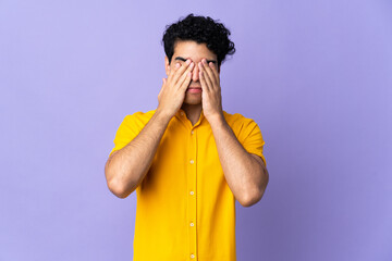 Young Venezuelan man isolated on purple background covering eyes by hands