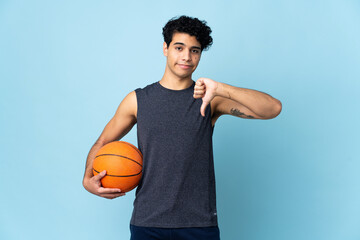 Obraz premium Venezuelan basketball player man over isolated background showing thumb down with negative expression