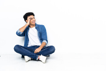 Venezuelan man sitting on the floor has realized something and intending the solution