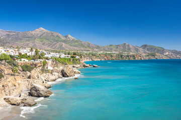 Fototapeta premium Nerja town, a resort of The Costa del Sol seaside region in Andalusia in the south of Spain, view from the Balcon de Europa square. Stunning coastal view with turquoise water.