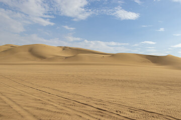 The sand dunes of Huacachina, Peru are a very popular tourist spot, where many try sandboarding or driving dune buggies.