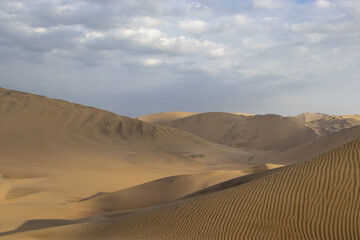 The sand dunes of Huacachina, Peru are a very popular tourist spot, where many try sandboarding or driving dune buggies.