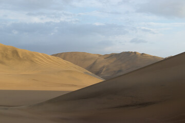 The sand dunes of Huacachina, Peru are a very popular tourist spot, where many try sandboarding or driving dune buggies.