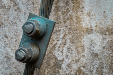 The image captures the contrast between the smooth metal of the bolt and the textured insulation of the wire.  