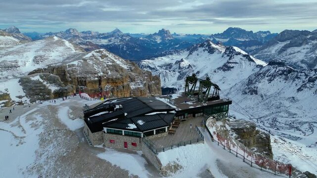 Stazione a Monte - Funivia Sass Pordoi in winter offers an unforgettable experience in the heart of the Dolomites. Captured by drone, the scene showcases the snowy summit station Passo Pordoi below