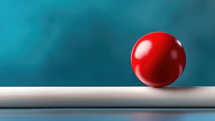 Shiny red sphere balancing on white cylindrical surface against blue background