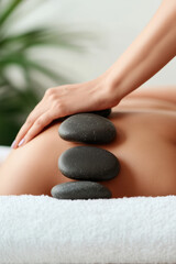 Woman enjoying exotic hot stones massage. Woman with stones on her body. Spa treatment concept, wellness day