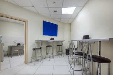A snack room in a modern office with high tables and bar stools. A convenient place to relax at lunchtime.
