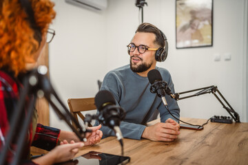 adult man host interviewer woman guest questions while record podcast