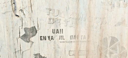 Obraz premium Old torn urban street posters background. White creased ripped paper placard texture background. Faded and weathered paper placard on the wall outdoors