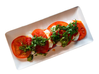 Appetizing caprese salad with mozzarella served with arugula on platter. Isolated over white background