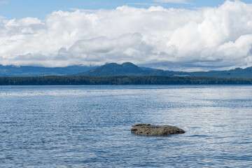 view from the shore of Malcolm Island beautiful water of the Queen Charlotte Strait with clouds on sky