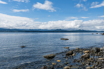 view from the shore of Malcolm Island beautiful water of the Queen Charlotte Strait with clouds on sky