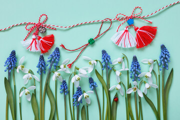 Snowdrop flowers, muscari, red and white martenitsa symbols of the March 1st Martisor holiday on green paper.
