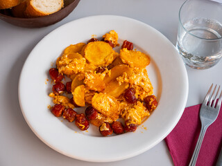 Huevos con chistorra - fried eggs with sausages served with potatoes