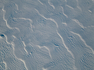 Frozen in motion: the play of light and shadow on the endless snowy expanses of the Arctic, captured from a bird's-eye view by a drone, creates a bizarre texture.