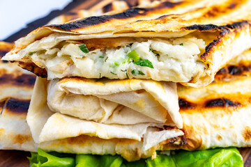 Grilled flatbread with creamy filling and herbs for outdoor dining