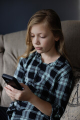 Portrait of girl Playing Game on phone. Relaxing in Living Room