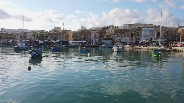 Lively and colorful harbor of the fishermen's village Marsaxlokk, seen from a pier