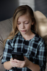Portrait of girl Playing Game on phone. Relaxing in Living Room
