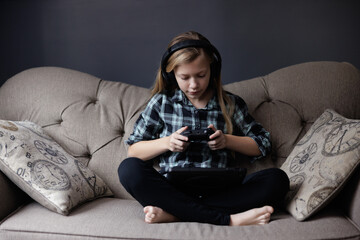 Portrait of girl Playing Game on phone. Relaxing in Living Room