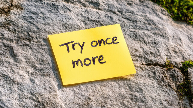Yellow note with motivational message on rock surface