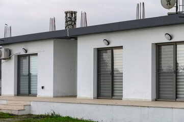 Modern architecture meets serene landscape with minimalist design on cloudy day in suburban environment