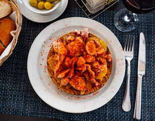 Chopped spicy boiled octopus tentacles with potato slices traditionally seasoned with aromatic smoked paprika