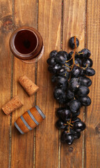 a glass of red wine and a bunch of grapes
