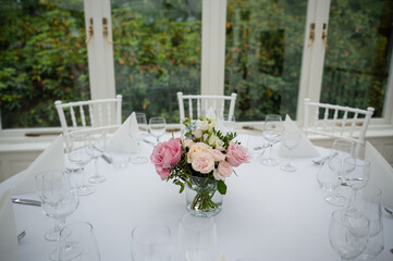 White stylish decorated restaurant interior with natural lighting for minimalist wedding celebration near the garden, no people, empty