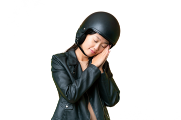 Young Asian woman with a motorcycle helmet over isolated chroma key background making sleep gesture in dorable expression