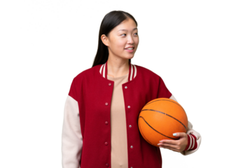 Young basketball player asian woman over isolated background looking side